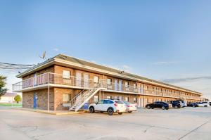 a building with cars parked in a parking lot at Motel 6-Salina, KS in Salina