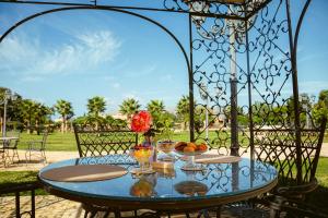a glass table with a bowl of fruit and flowers on it at Villa del Gattopardo in Palermo