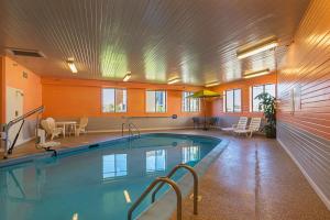 a large swimming pool with chairs and a table and a tablektop at Motel 6-Waterloo, IA - Crossroads Mall - Cedar Falls in Waterloo
