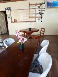 a dining room with a wooden table and white chairs at Dreamland Tour in Santa Teresa
