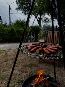 a bunch of sausages on a grill next to a fire at Apartament Bydlino in Bydlino