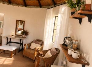 a room with chairs and a table and a window at The Thatched Hideaway on Stanmore farm in Nottingham Road