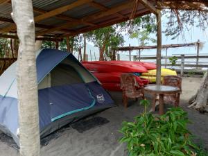 a tent and some kayaks on the beach at Dreamland Tour in Santa Teresa