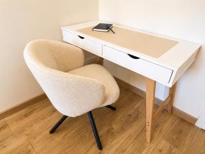 a desk with a chair next to a white desk at L'Escale Strasbourgeoise climatisée in Strasbourg