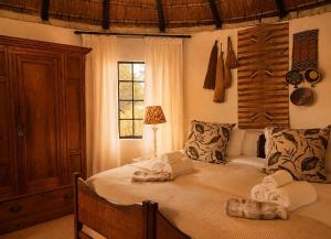 a bedroom with a large bed with towels on it at The Thatched Hideaway on Stanmore farm in Nottingham Road