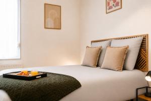 a bedroom with a large bed with a tray on it at Le Triplex Confort I Parking gratuit I Centre Amiens in Amiens
