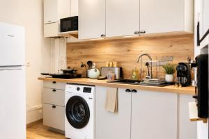 a kitchen with white cabinets and a washing machine at Le Triplex Confort I Parking gratuit I Centre Amiens in Amiens