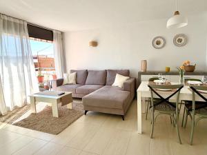 a living room with a couch and a table at Ático en Cubelles playa in Cubelles