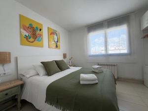 a bedroom with a large bed with a green blanket at Ático en Cubelles playa in Cubelles