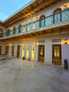 a large courtyard with a balcony and a patio at Khalid Boutique in Bukhara