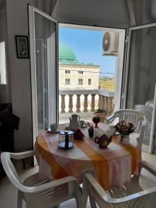 a dining room table with a view of a balcony at Appartement spacieux - Dar Chaabane plage in Nabeul +5 photos