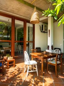 a patio with a wooden table and chairs at Baker's cottage in Kosgoda