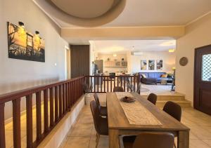 a living room with a wooden table and chairs at PetraCasa Luxury Villa in Azolimnos Syros