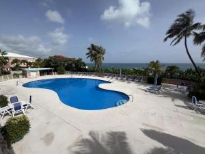a swimming pool with chairs and a view of the ocean at East End Escape in Christiansted