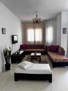 a living room with a couch and a table at Appartement spacieux - Dar Chaabane plage in Nabeul