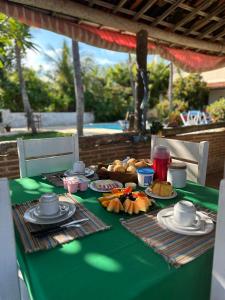 a green table with plates of food on it at Pousada Casa do Josef in Canoa Quebrada