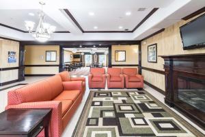 a waiting room with orange chairs and a flat screen tv at Motel 6-Joshua, TX in Joshua