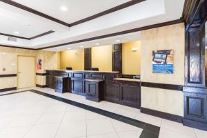 a large kitchen with wooden cabinets and tile floors at Motel 6-Joshua, TX in Joshua