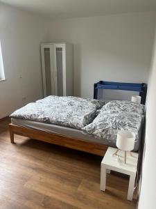 a bedroom with a bed and a white table at Ferienwohnung Landhege in Michelfeld