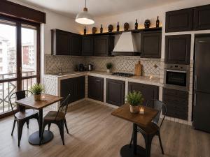 a kitchen with black cabinets and two tables and chairs at Il Rovo Rooms in Porto Torres