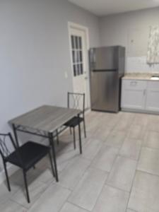 a kitchen with a table and a stainless steel refrigerator at Flawless one bedroom apartment! in Houston