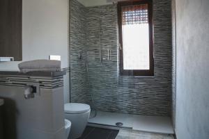 a bathroom with a toilet and a window at Il Rovo Rooms in Porto Torres +9 photos