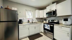 a kitchen with white cabinets and a stainless steel refrigerator at Flawless one bedroom apartment! in Houston