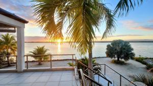 a view of the ocean from a house with a palm tree at Grand Sunset Decks Luxury Home on the Lagoon in Maya Beach
