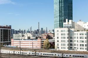 a view of a city with a train and buildings at Feather Factory Hotel in Queens