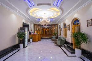 a lobby with a chandelier and a hallway with chairs at Khalid Boutique in Bukhara