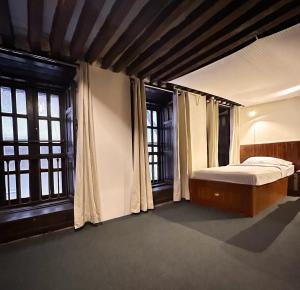 a bedroom with a bed and two windows at Newa Inn Homestay in Kathmandu