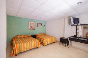a bedroom with two beds and a television in it at Hotel Playa Azul in Catemaco +42 photos