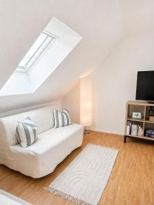 a living room with a white couch and a tv at All Homes Apartments Bad Schallerbach in Bad Schallerbach