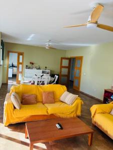 a living room with a yellow couch and a table at Casa La Fuente in Chella