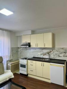 a kitchen with white cabinets and a stove top oven at WISH Apartment Sarajevo in Sarajevo