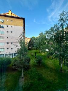 a green yard with trees in front of a building at WISH Apartment Sarajevo in Sarajevo