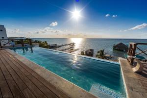 a swimming pool with a view of the ocean at Sandbar Beachfront Hotel & Hostel Restaurant in San Pedro