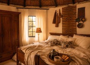 a bedroom with a bed with a tray of food on it at The Thatched Hideaway on Stanmore farm in Nottingham Road