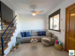 a living room with a couch and a ceiling fan at Adosado Primera línea de mar Playa de Puzol con Piscina y terrazas in Playa de Mar