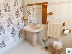 a bathroom with a sink and a shower curtain at Adosado Primera línea de mar Playa de Puzol con Piscina y terrazas in Playa de Mar