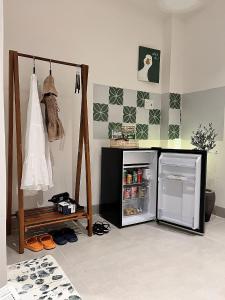 a room with a small refrigerator and a shelf at Cỏ Lá Homestay in Danang