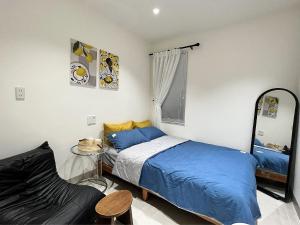 a bedroom with a bed and a chair and a mirror at Cỏ Lá Homestay in Danang