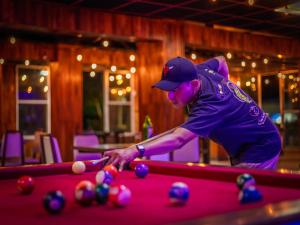 a man playing pool on a pool table at Hotel Playa Azul in Catemaco
