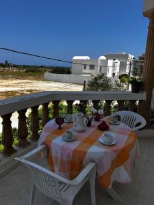 a table with a tea set on a balcony at Appartement spacieux - Dar Chaabane plage in Nabeul