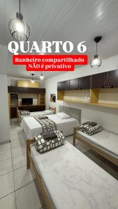 a room with three beds and a sign that reads zampa complimentary complimentary at Casa do Loro Hospedagem in Curitiba