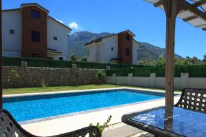 a swimming pool in a yard with two buildings at Cesur Villa in Fethiye