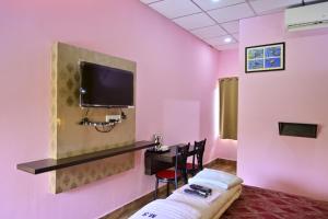 a room with a bed and a desk and a tv at HOTEL SHREESH (NEIL) in Neil Island