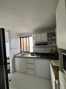 a kitchen with white cabinets and a sink at aprtamento CTG in Cartagena de Indias