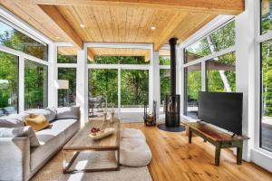 a living room with a couch and a tv at La Trêve Mont Tremblant in La Conception