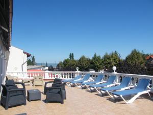 a row of lounge chairs on a patio at Y Panzió in Balatonlelle +12 photos